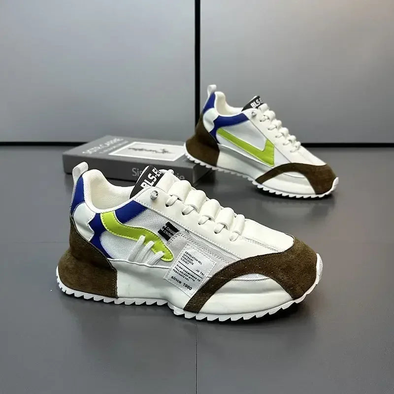 Pair of white, brown, and green summer sneakers on a reflective surface with a gray background.