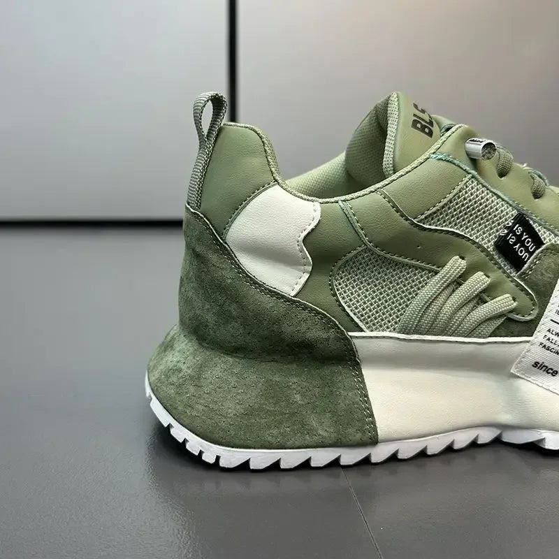 The back of a green and white summer sneaker on a gray surface with a neutral background