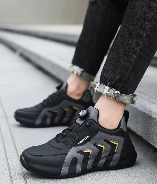 Black and gray athletic shoes worn with black jeans on a light background