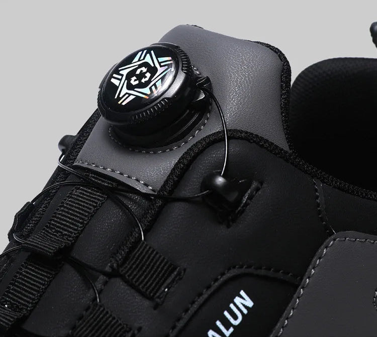 Black shoe with a central button detail on a gray background