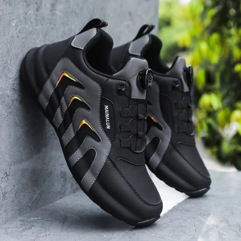 Black and grey sneakers with a brand logo on a gray surface.