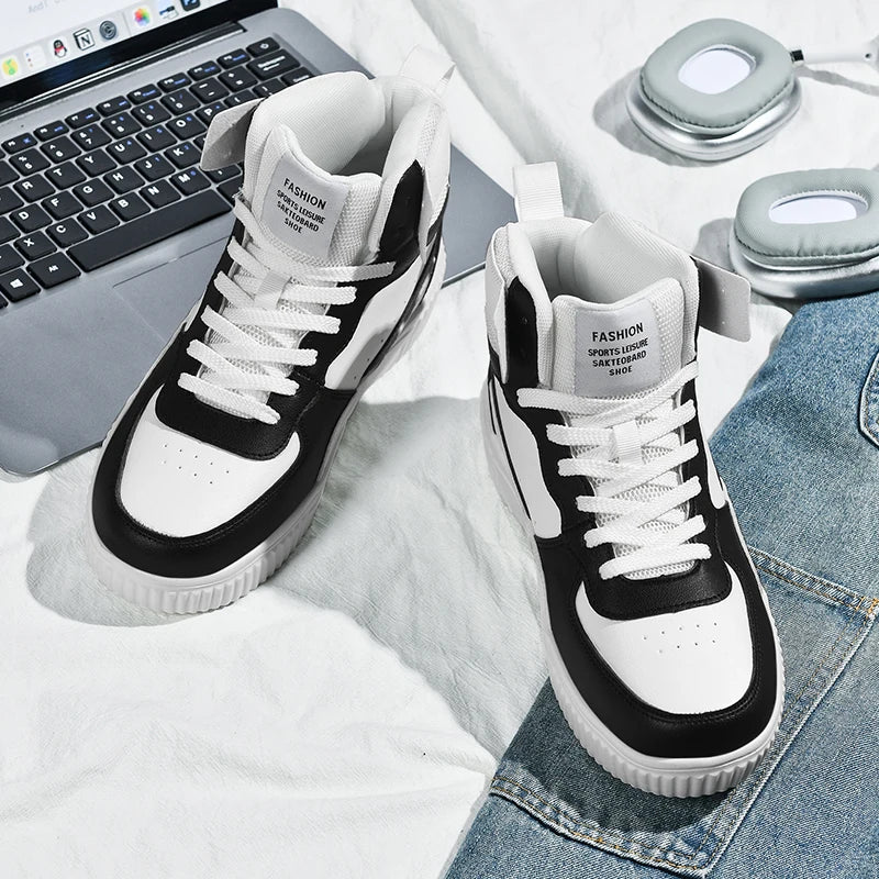 Black and white sneakers on a surface with a laptop and jeans in the background