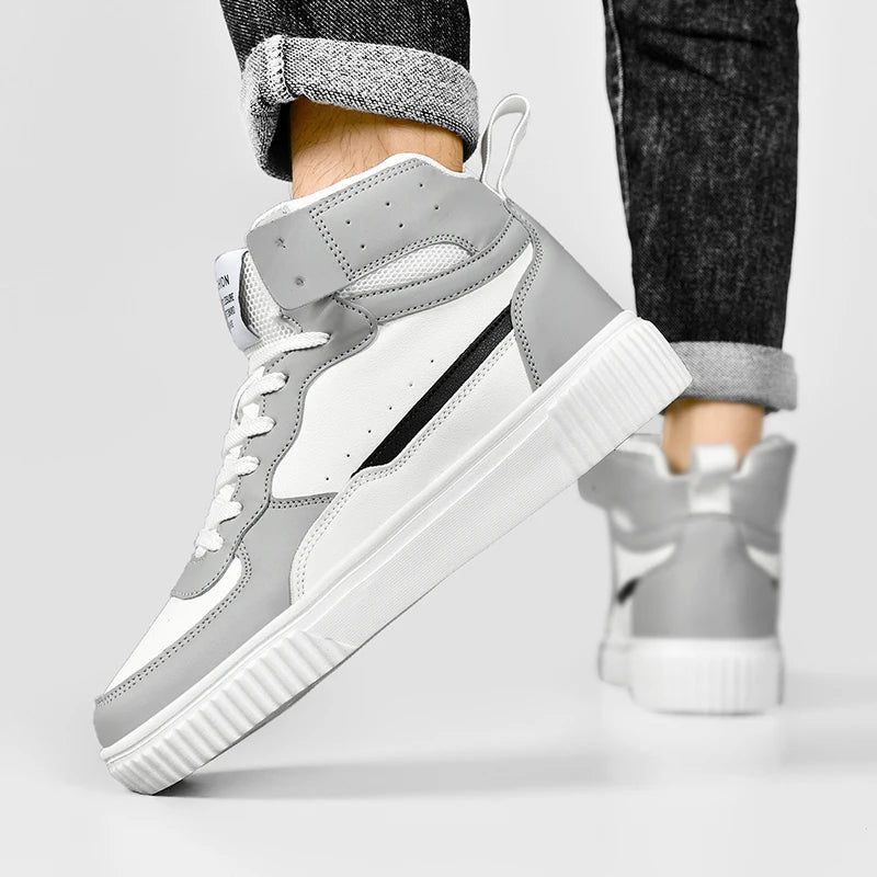 Gray high-top sneakers with white soles worn by a person on a light gray background