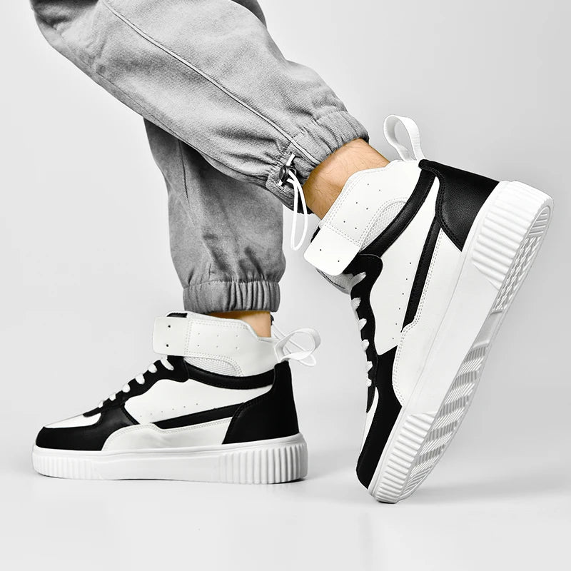 Black and white sneakers worn with gray pants on a light gray background