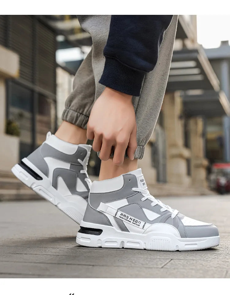 Gray and white sneakers worn by a person on a city street.
