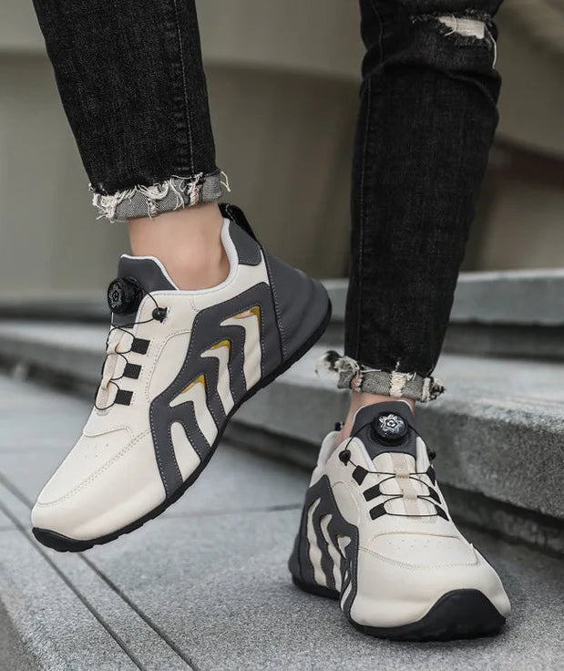 White and black sneakers worn by a person stepping onto a concrete surface.