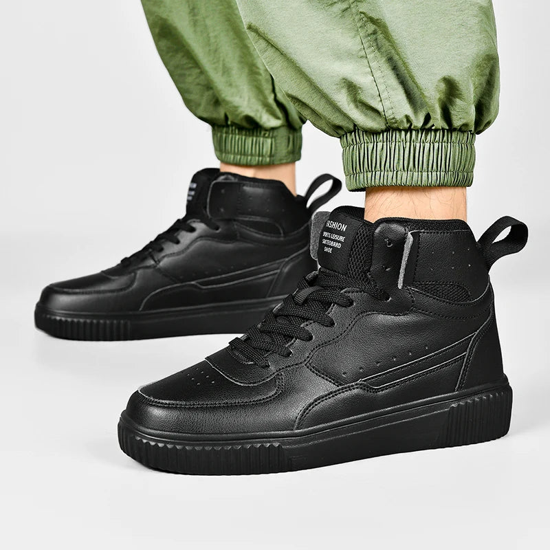 Black high-top sneakers worn with green pants on a light gray background