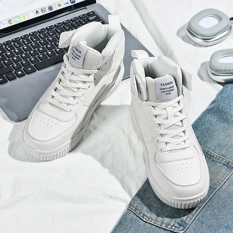 White sneakers on a surface with a laptop and jeans in the background