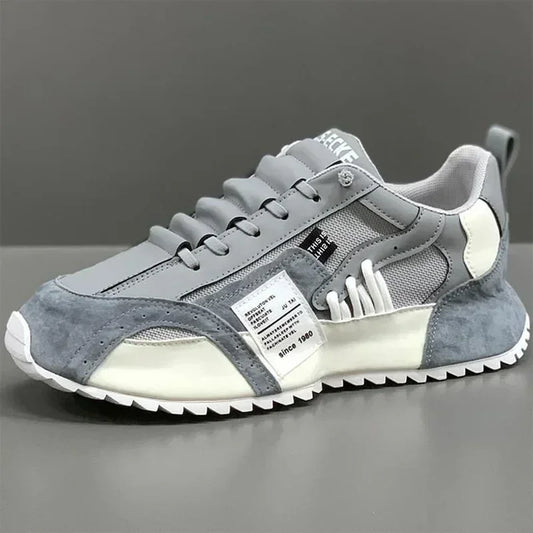 Gray and white summer sneaker with a visible brand label on a gray background