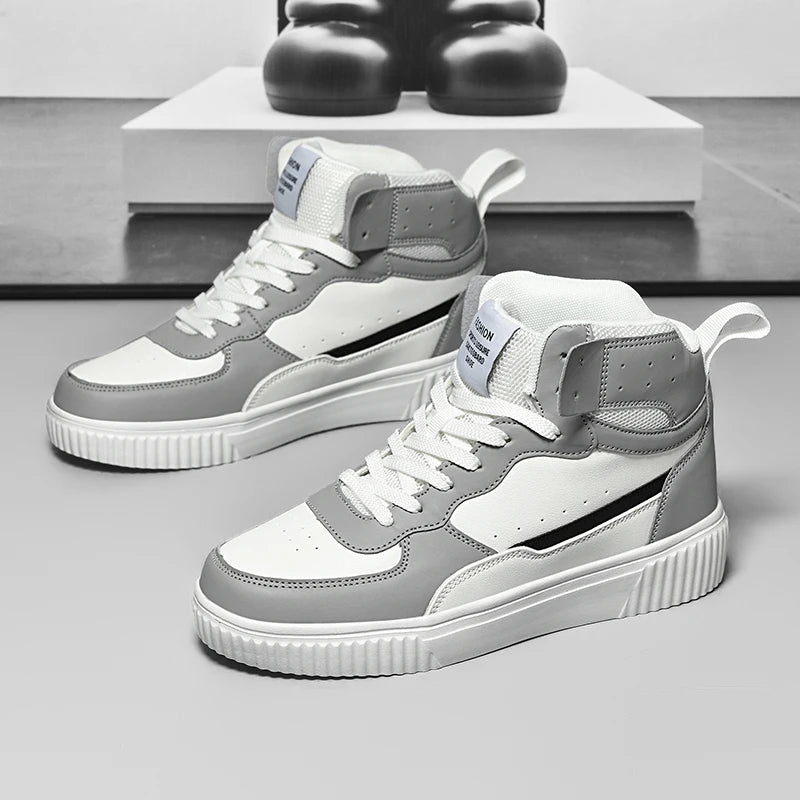 Gray and white high-top sneakers on a gray surface with a blurred background