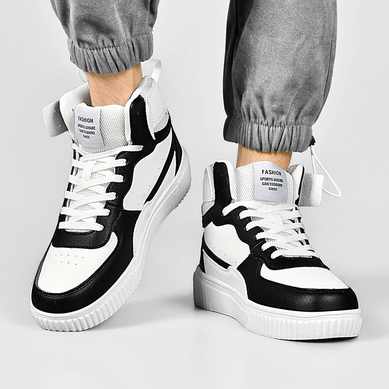 Black and white sneakers worn with gray pants on a light gray background