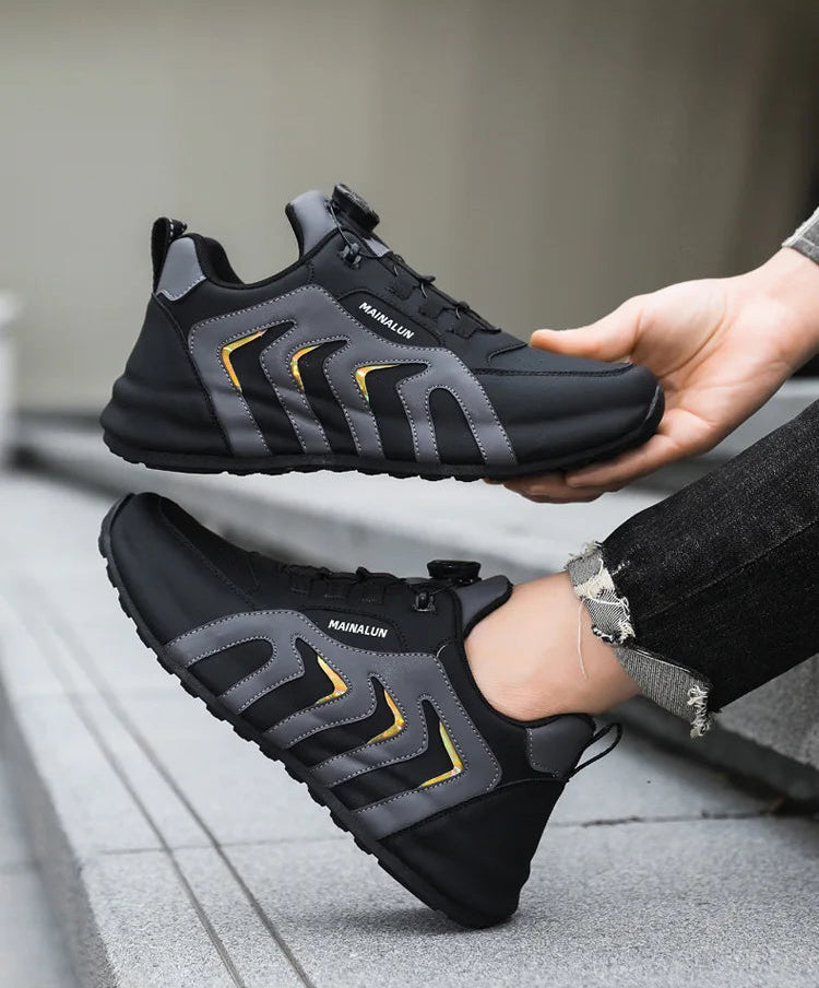 Black and gray sneaker with yellow accents held by a hand on a white background