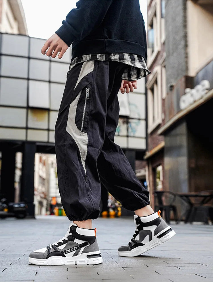 Person wearing black and white fashion shoes on a city street.