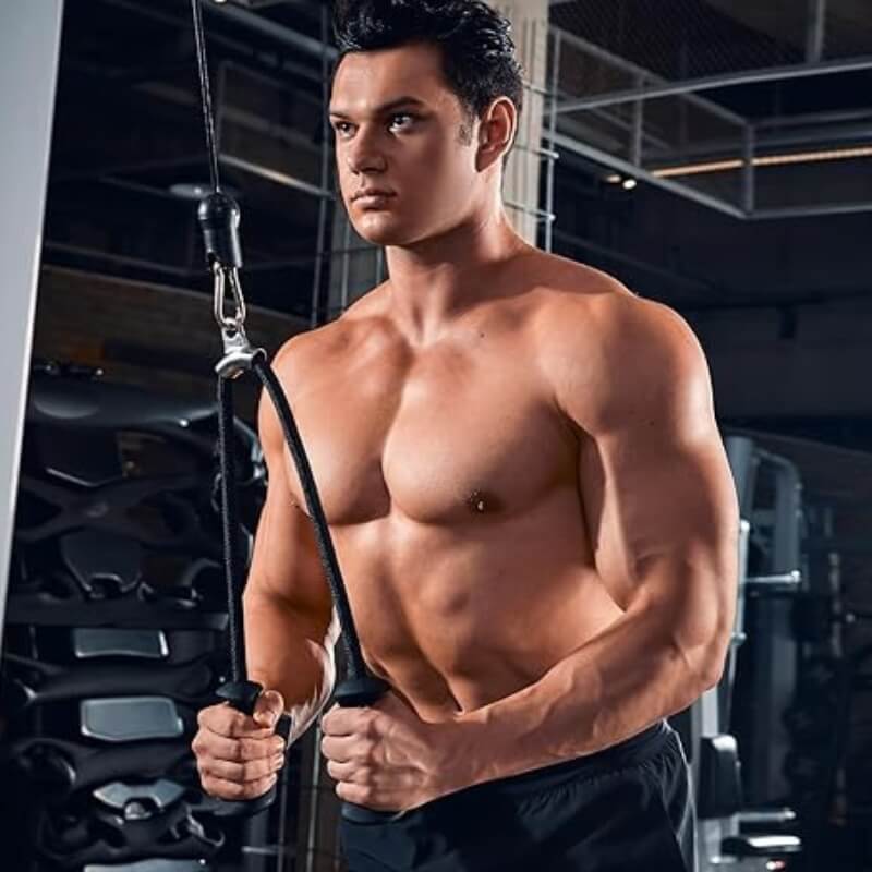 Muscular man in a gym using tricep rope attachment