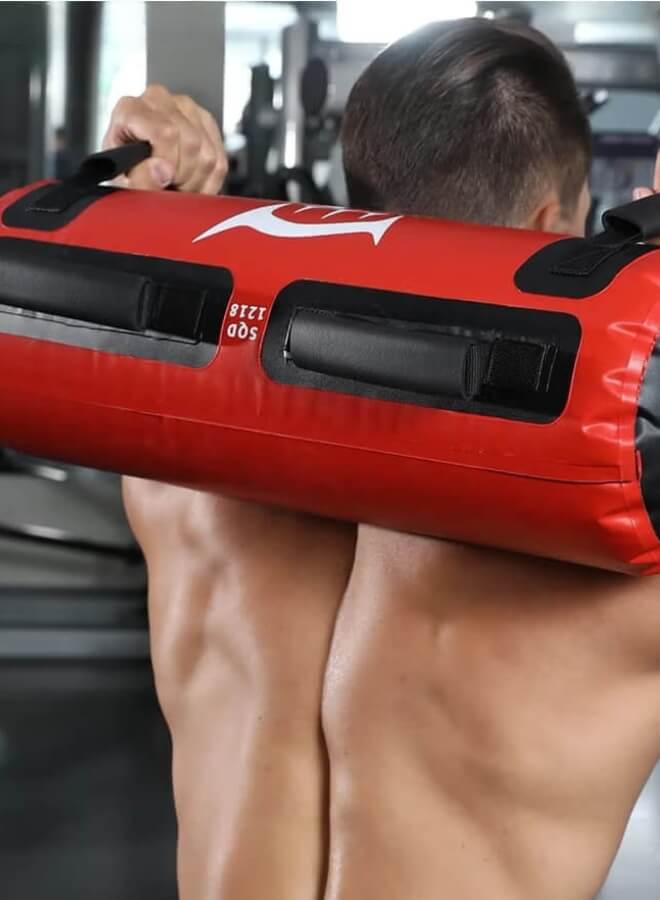 Person holding a red and black water weight bag​ in a gym setting