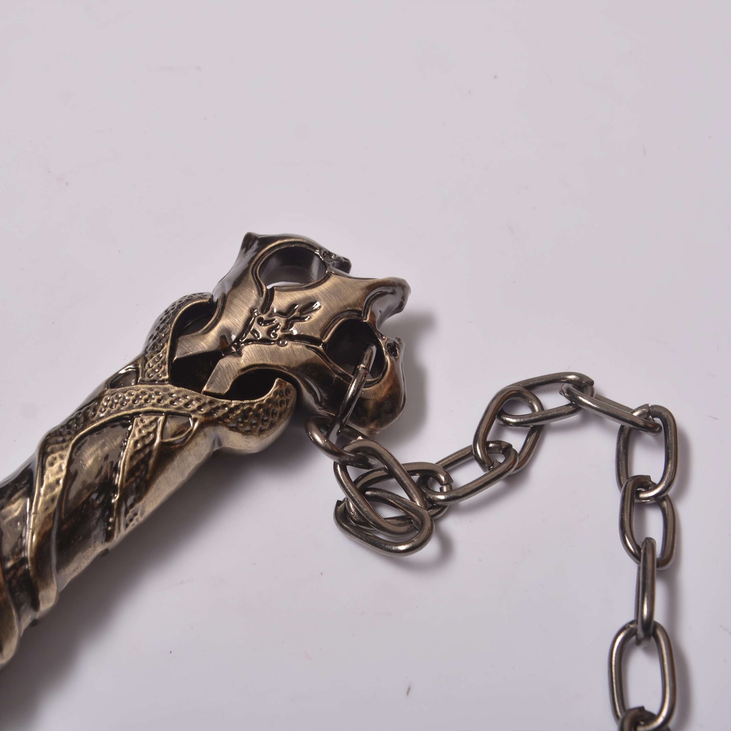 Decorative metal object with chain on a white background