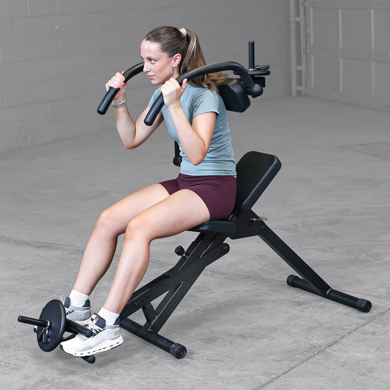 Woman exercising on a semi-recumbent ab bench in a home setting