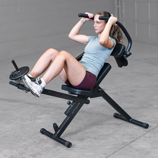 Woman exercising on a semi-recumbent ab bench in a garage setting