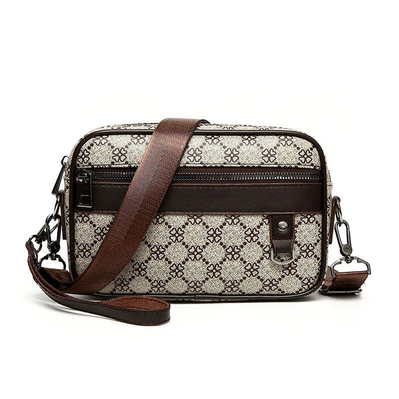 Patterned leather toiletry bag with brown strap and accents on a white background