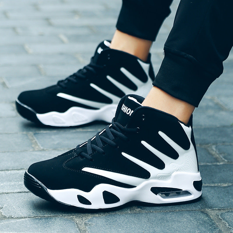 Black and white sneakers on a person's feet on a pavement.