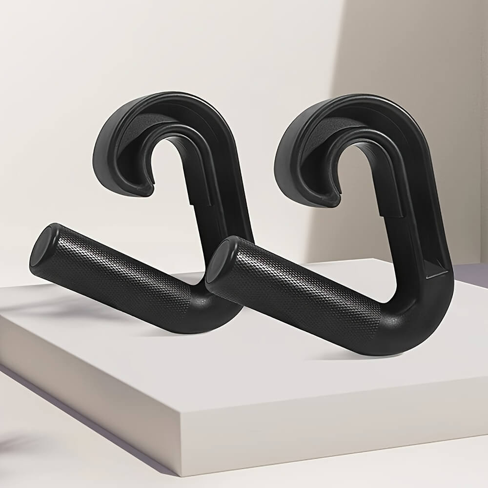 Black pull up grips on a white platform with a neutral background
