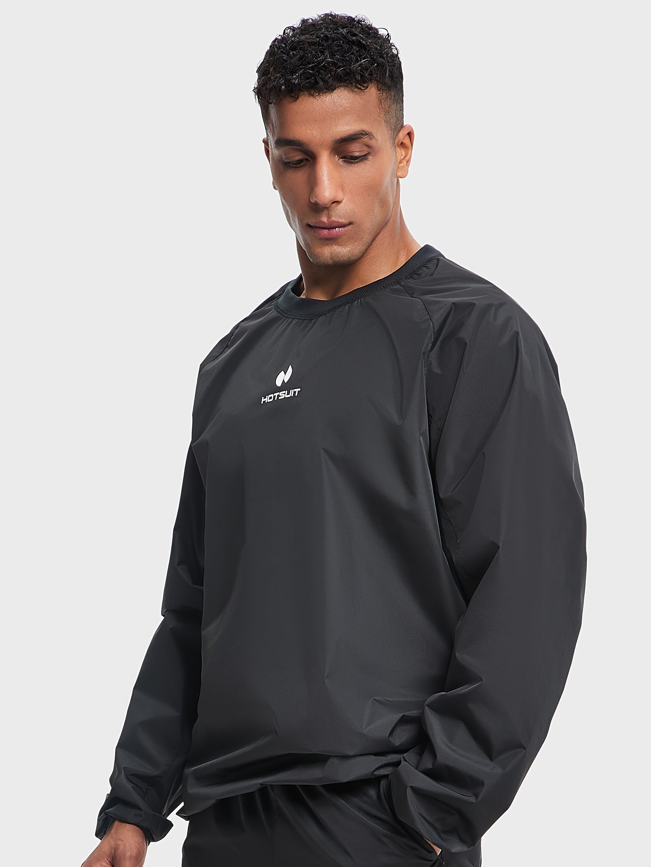 Man wearing a black sauna sweat suit top with a visible brand logo on a light gray background
