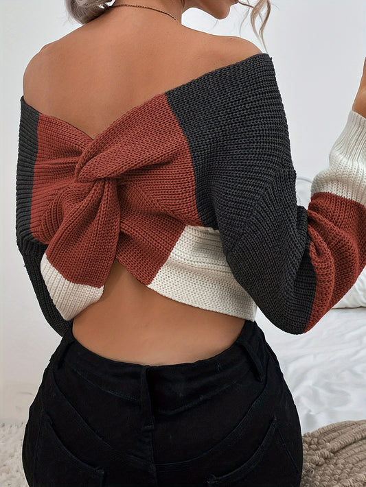 Woman wearing a colorful off the shoulder sweater with a knot design on a white background