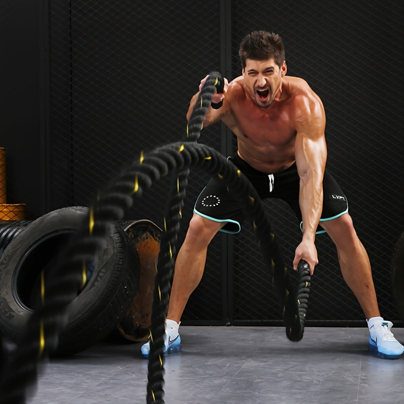 Man exercising with exercise battle ropes in a gym setting