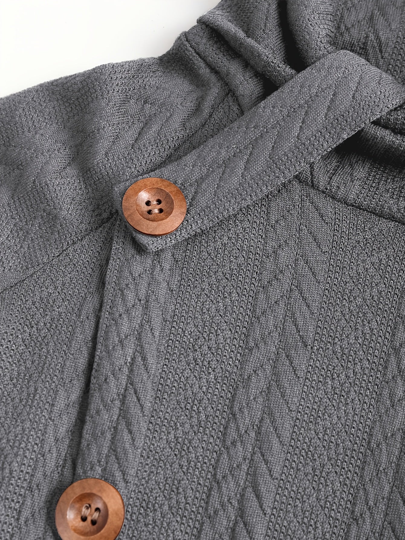 The buttons on the front view of a grey women's cable knit cardigan sold by 100 spartans