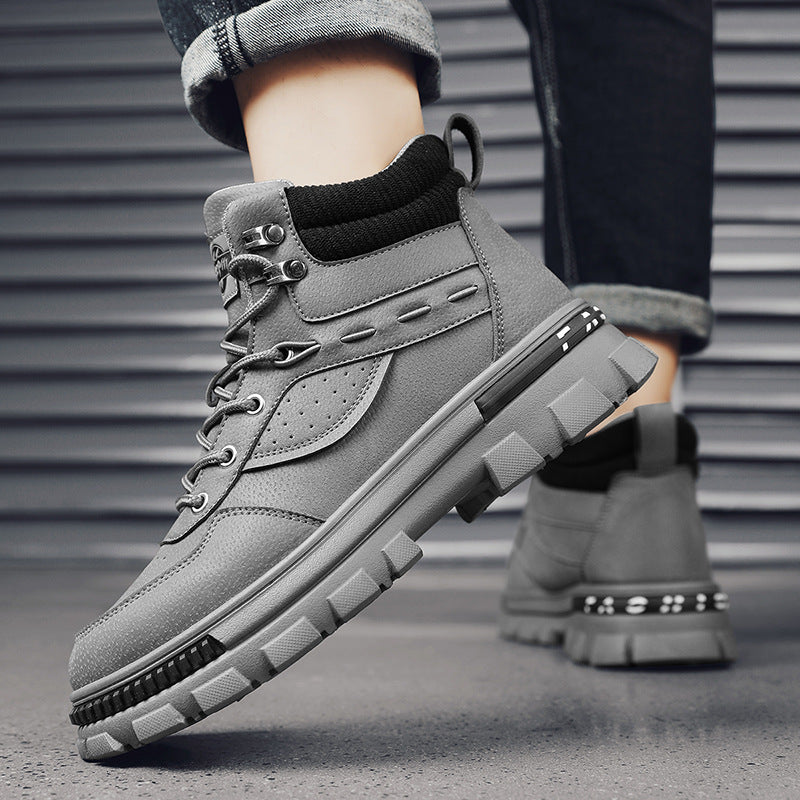 A person wearing a pair of grey Martin high top boots