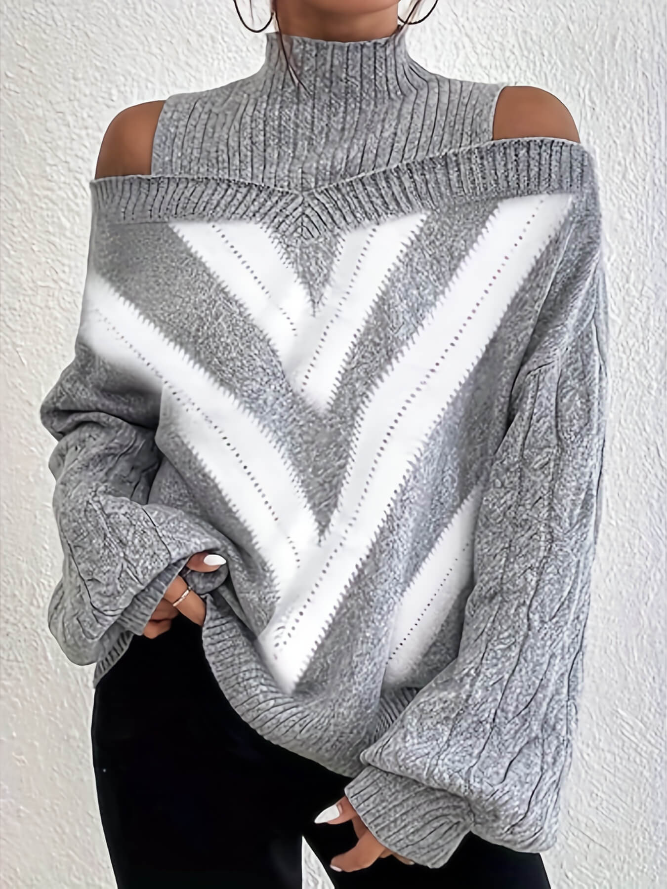 Gray off the shoulder sweater with a white zigzag pattern worn by a person against a white background