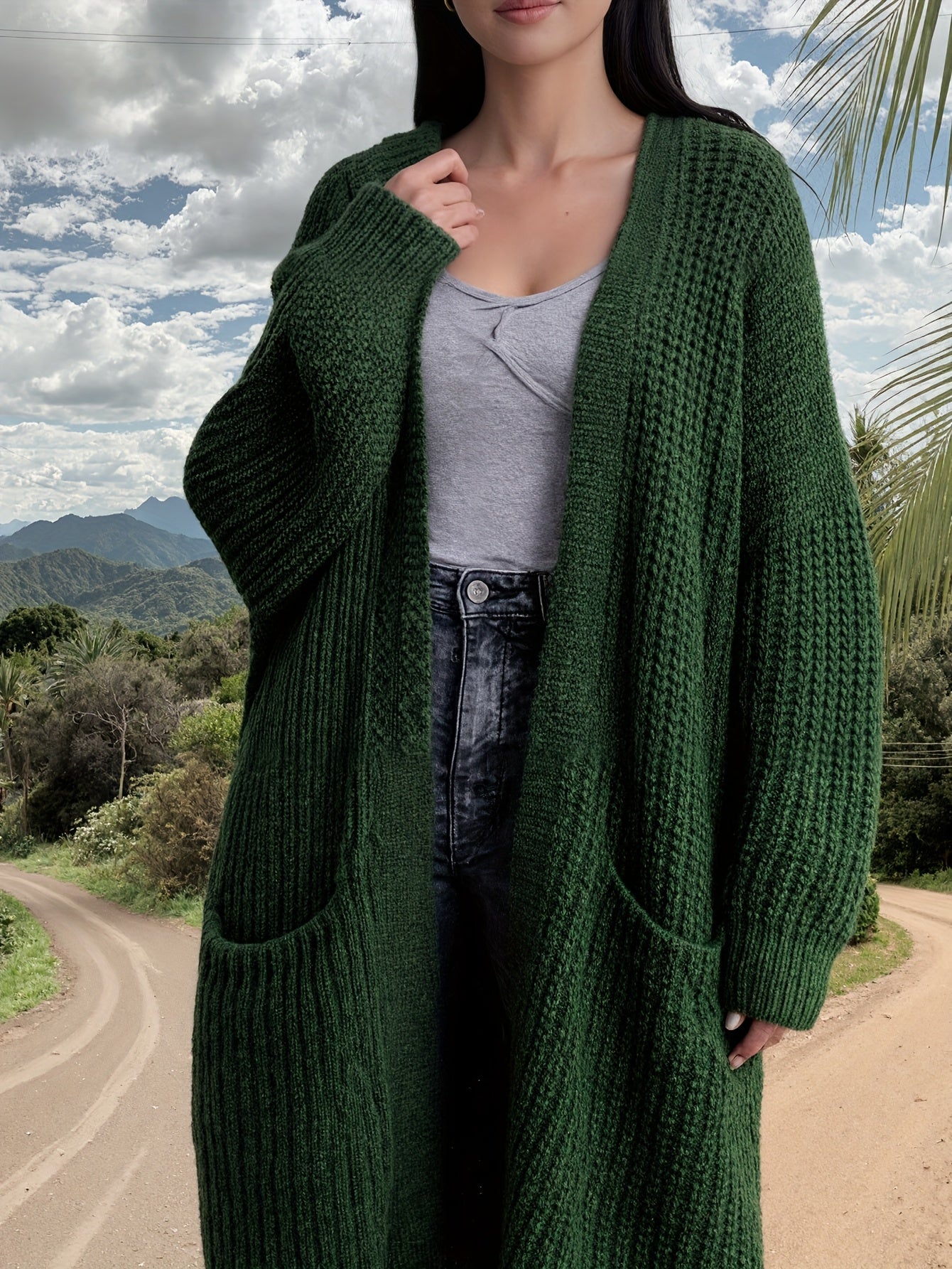 Person wearing a green knitted cardigan outdoors with a scenic background