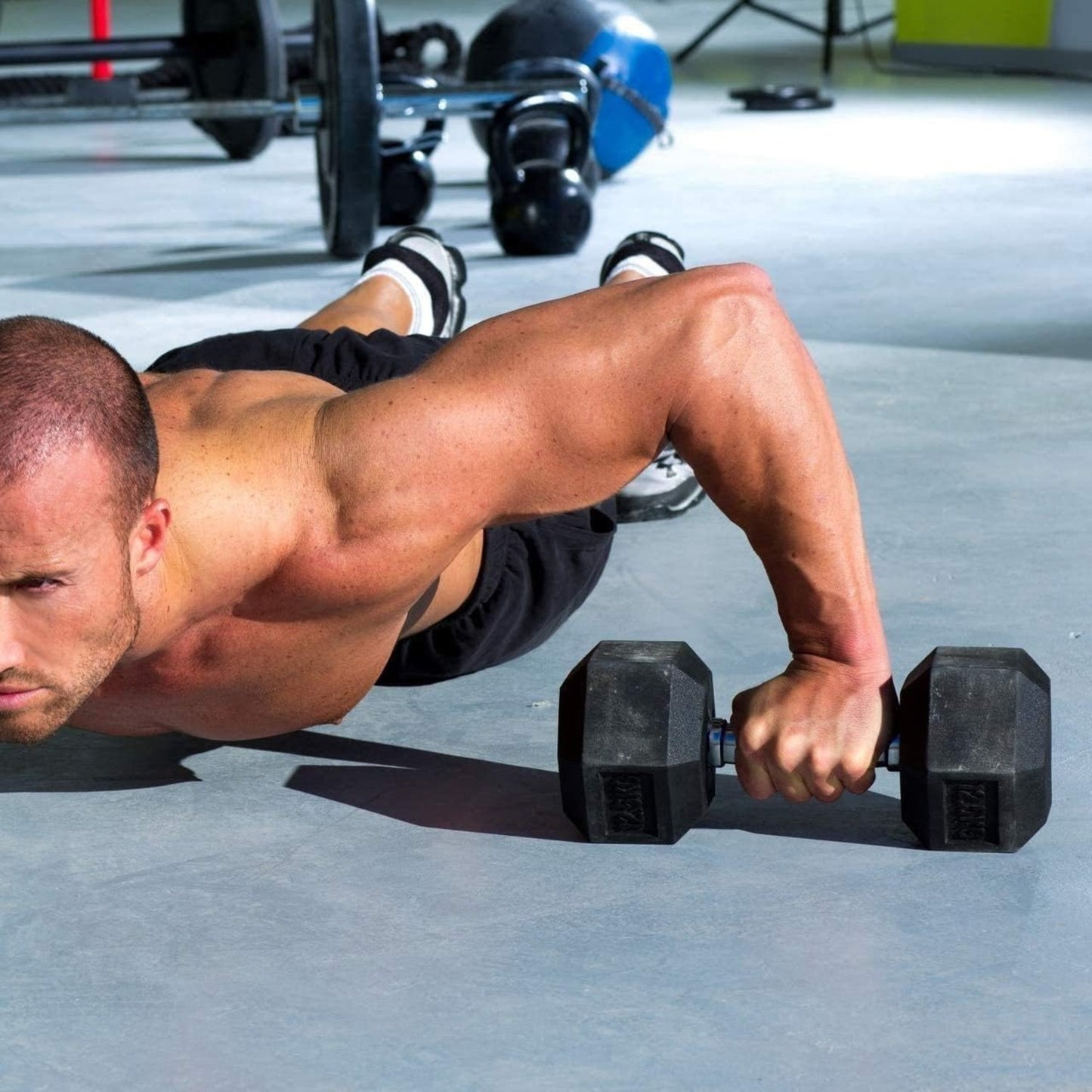 Man performing push-ups with hex dumbbells in a gym setting