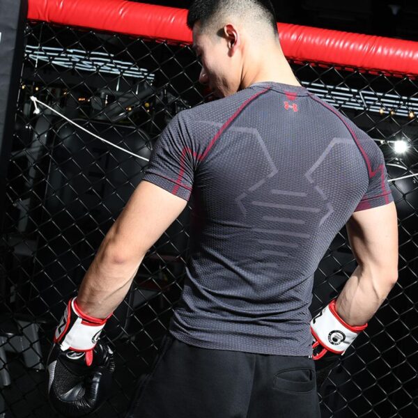 A fit man standing wearing a black 100 Spartans® Boxing Gloves by zooboo sport