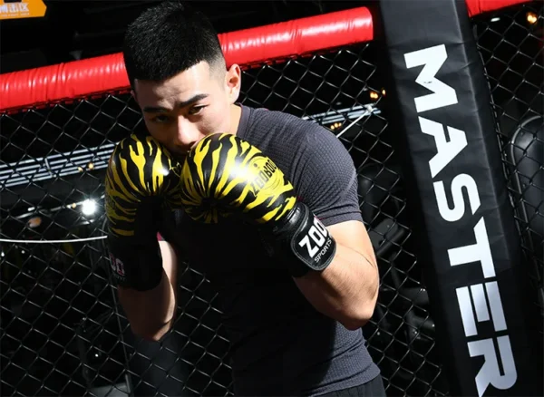 A man in the ring wearing yellow tiger stripes boxing gloves