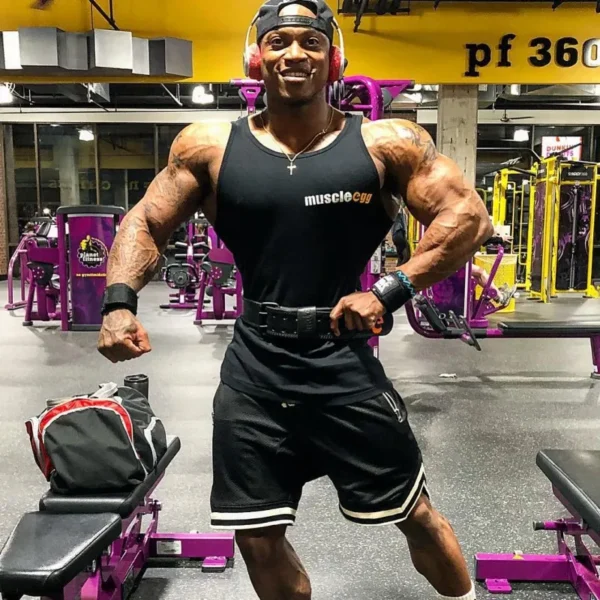 A man working out in the gym, wearing a black mens tank top and black gym shorts sold by 100 Spartans