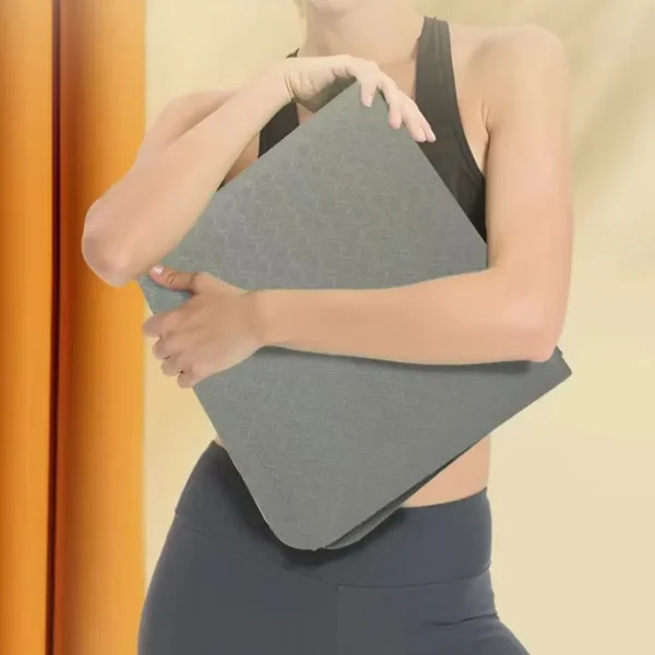 Someone holding a folded foldable yoga mat sold by 100 Spartans