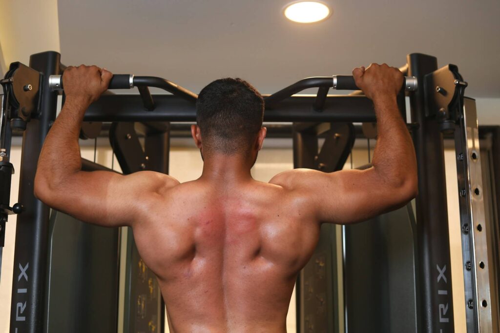 A man doing pull ups a back exercise to boost back muscles