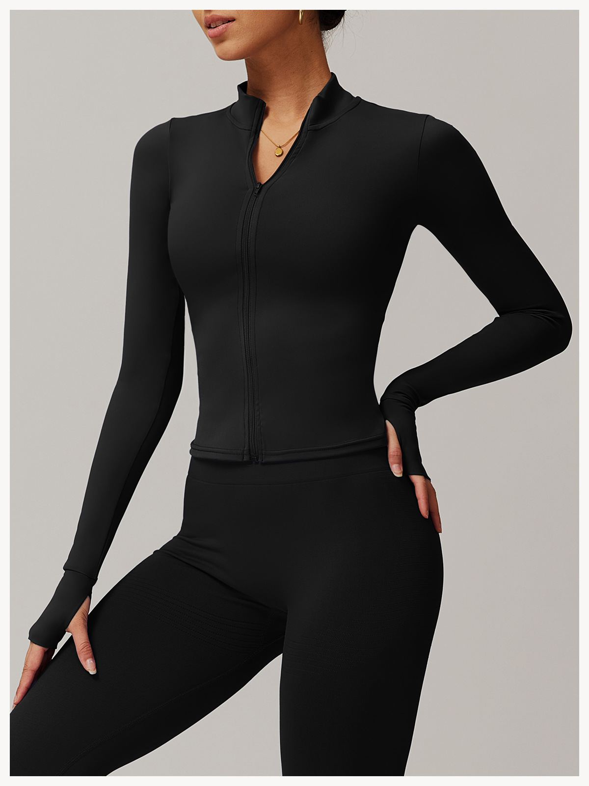 A woman wearing a black 3 piece womens tracksuit sold by 100 spartans