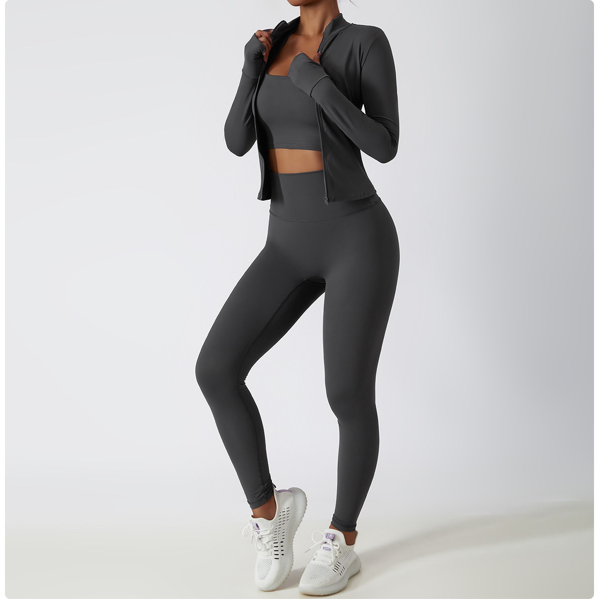 A woman wearing a dark gray 3 piece womens tracksuit sold by 100 spartans