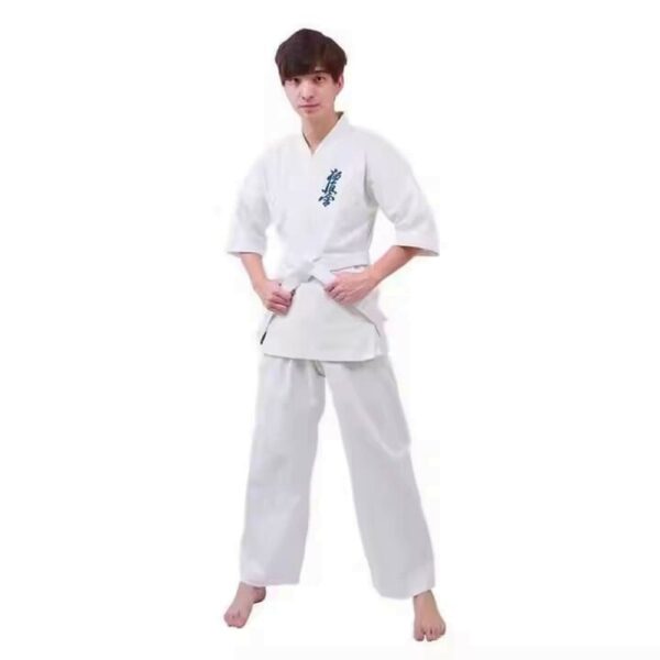 A man wearing a 12oz white Kyokushin Karate Uniform sold on 100 Spartans