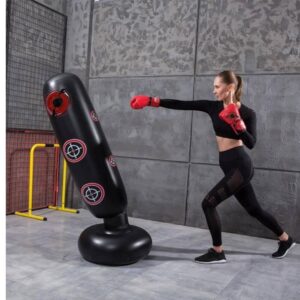 A woman practicing with a punching bag with stand sold on 100 Spartans