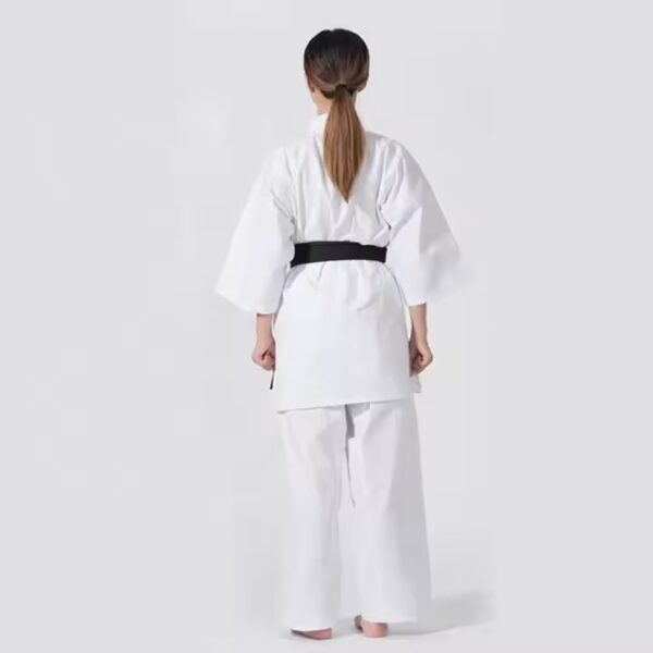 The back view of a woman wearing a 12oz white Kyokushin Karate Uniform sold on 100 Spartans